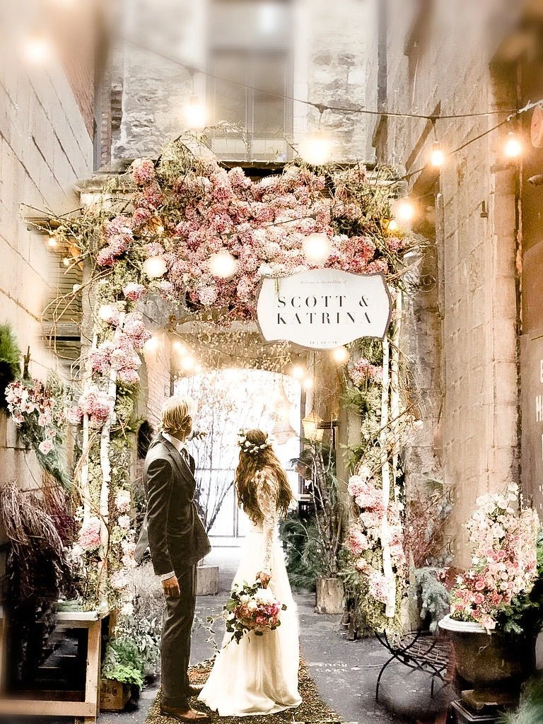 A previous wedding beneath the floral arch at Maison Pepin